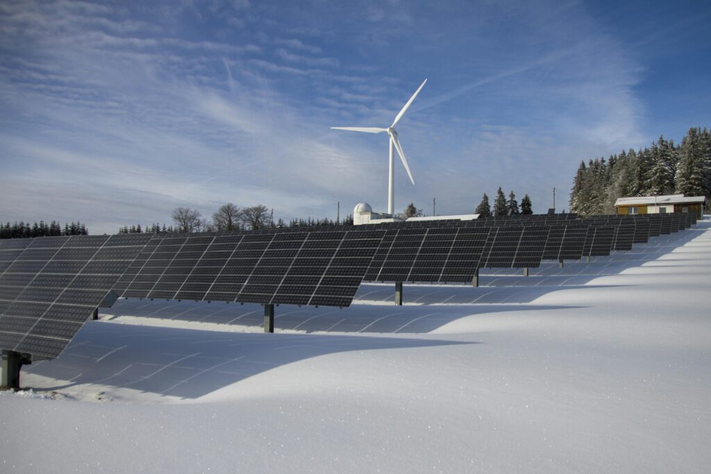 pexels-photo-433308-433308 Solar panels and wind turbine in a snowy landscape, showcasing renewable energy sources.